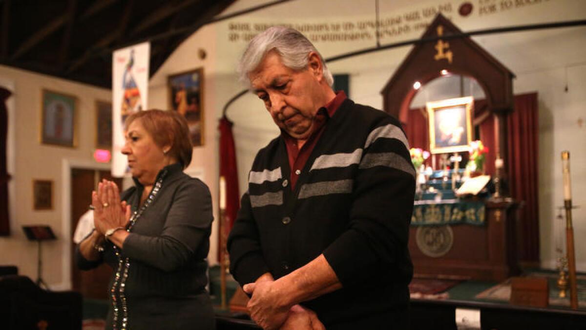 Sako Hakopian, de 69 años, a la derecha, y su esposa Ripsik, de 65, hablan acerca de cómo ellos realizan “matagh” u ofrendas, como parte de su fe en la Armenian Church, en Glendale.