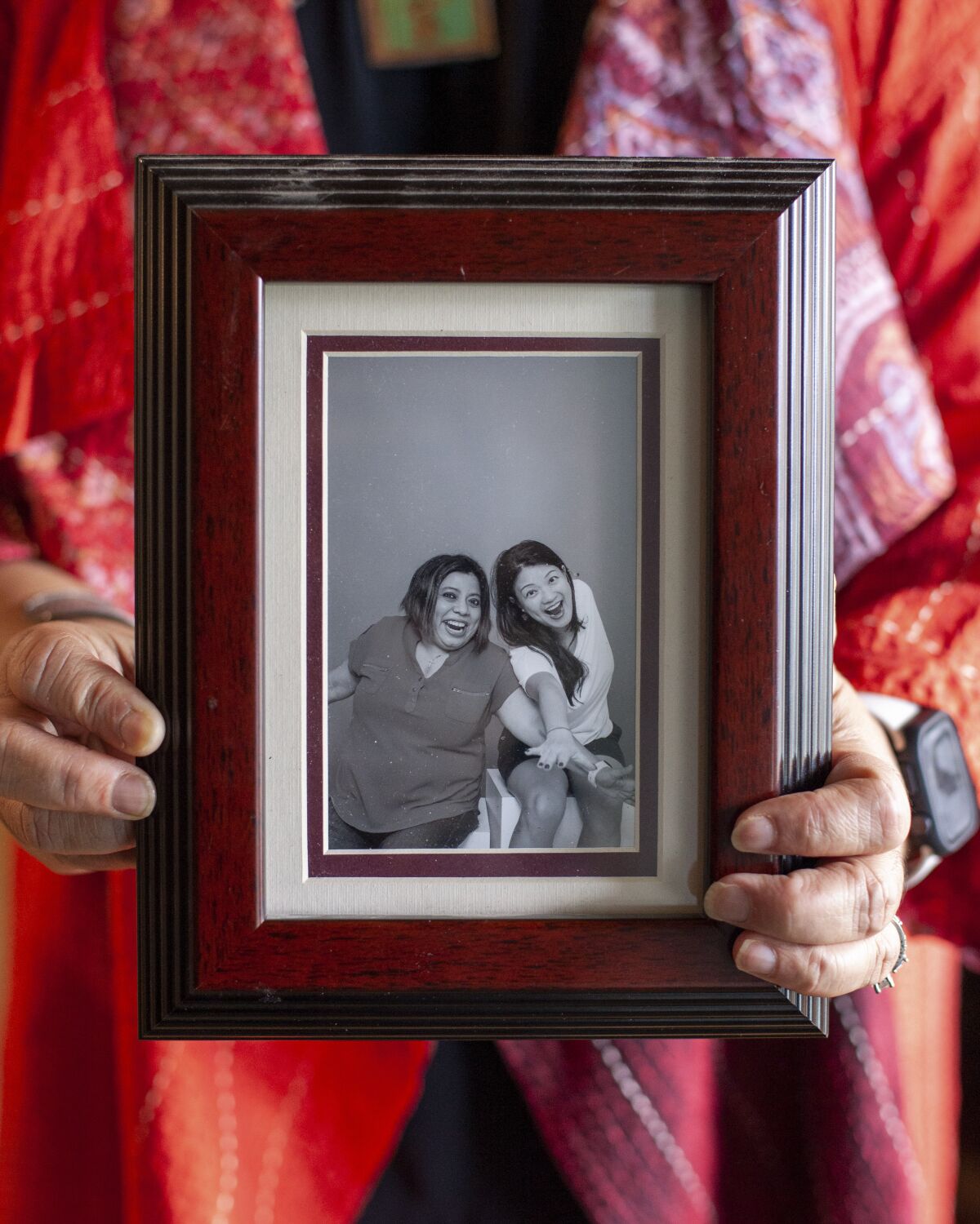 At her home in Seattle, Shila Das holds a picture of herself with her best friend, Wendy Chua.