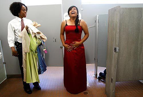 Cristina Itzep, 18, of Van Nuys reacts to a prom dress she's trying on Fulton College in Van Nuys with the help of Tene Carter Miller, left, of Los Angeles.