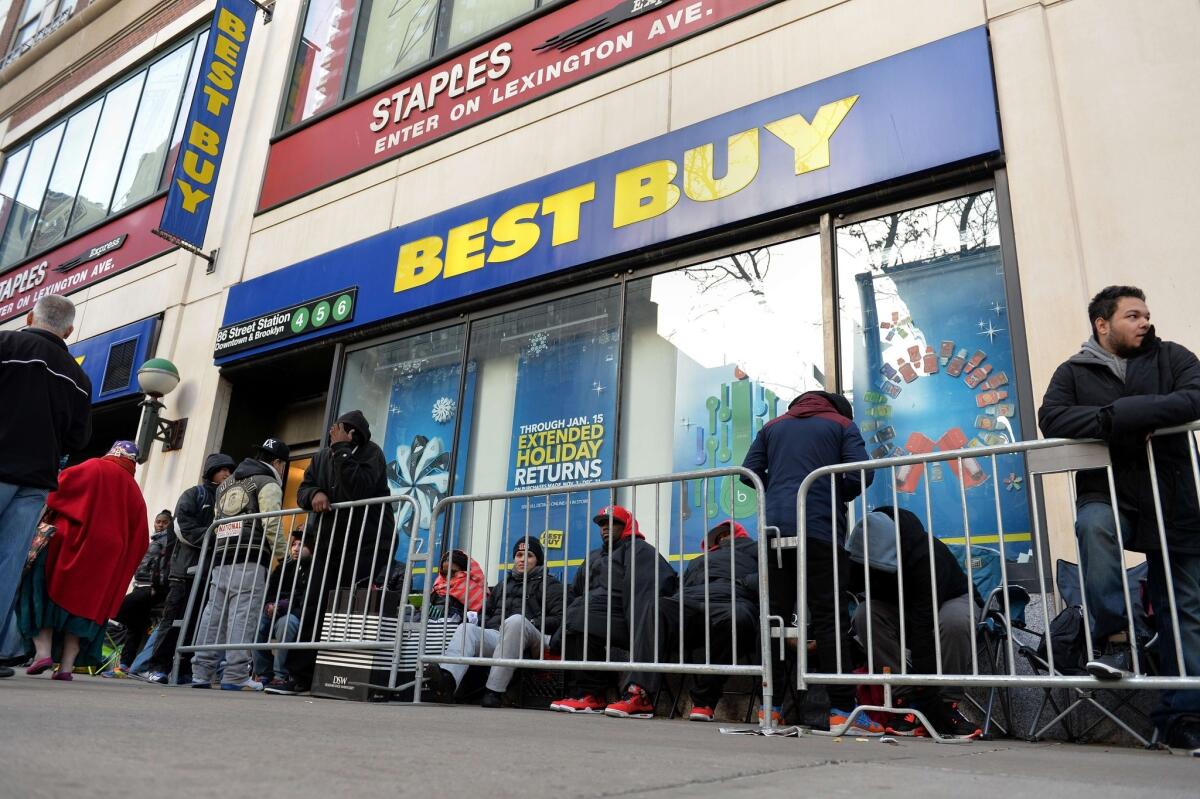 People wait in line to buy the latest PlayStation console at a New York Best Buy store.