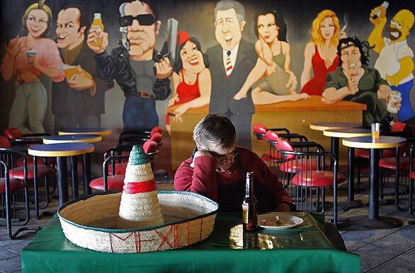 Jose Belaza, owner of Señor Maguey's in Tijuana, dozes while waiting for patrons. Since 2005, tourist visits to Tijuana have fallen 90% and a recent wave of violence has driven another nail into the coffin of the tourism industry. But merchants say beautification efforts and police crackdowns have left downtown safer and spiffier than in years.