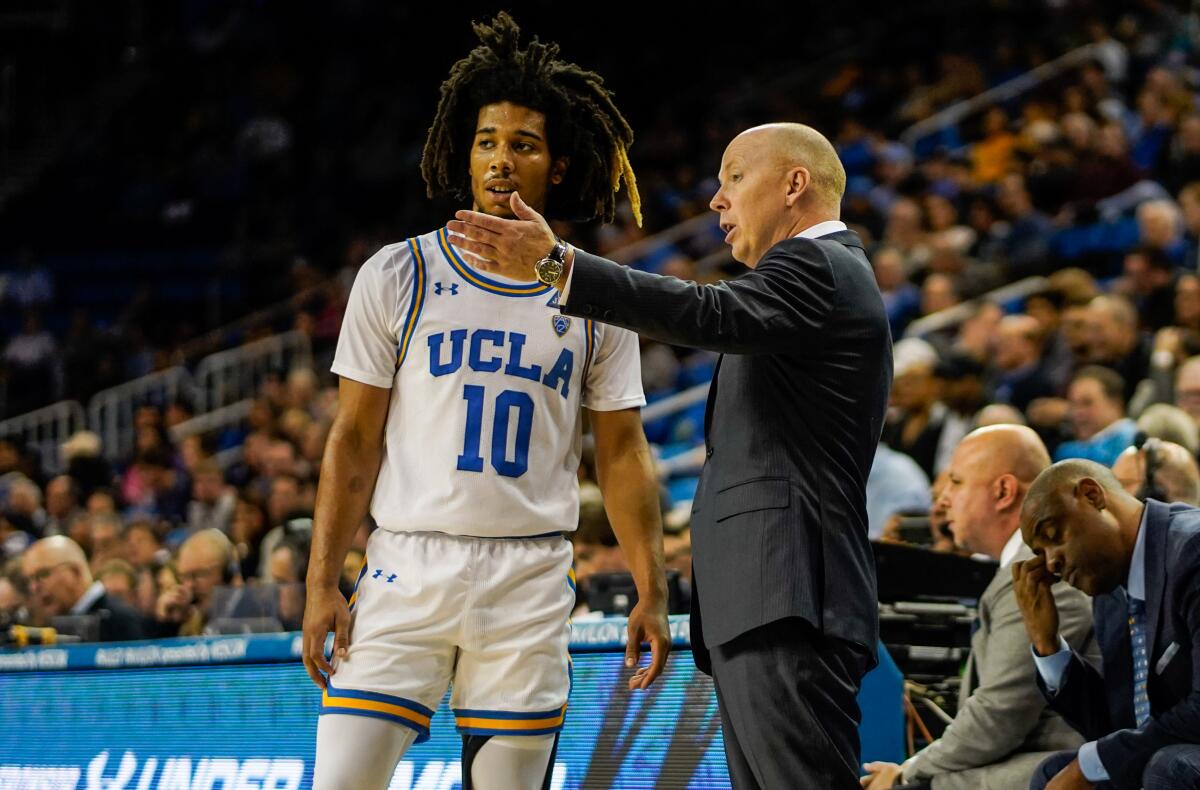 UCLA guard Tyger Campbell talks with coach Mick Cronin during the Bruins' season-opener against Long Beach State.