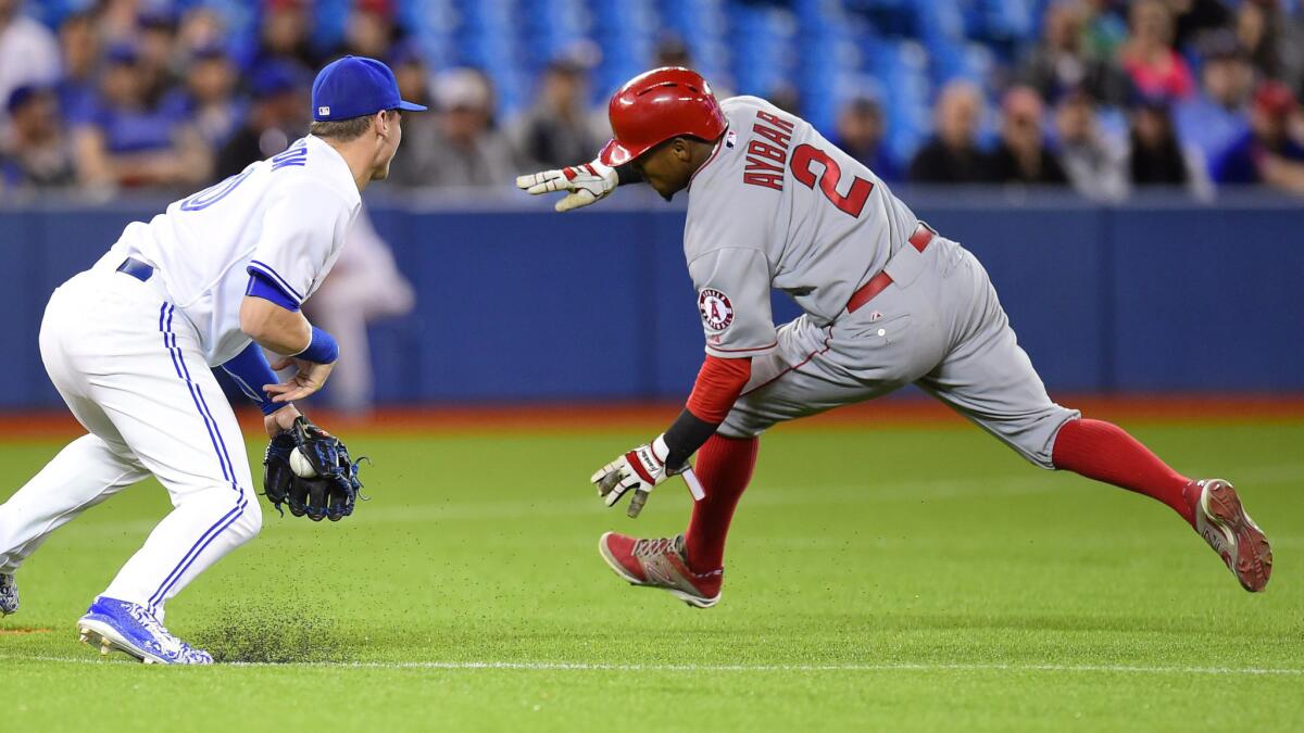 Toronto's Josh Donaldson, left, can't make the tag on Angels' Erick Aybar before he slides safely into third base during the eighth inning of the Angels' 3-2 win Tuesday.