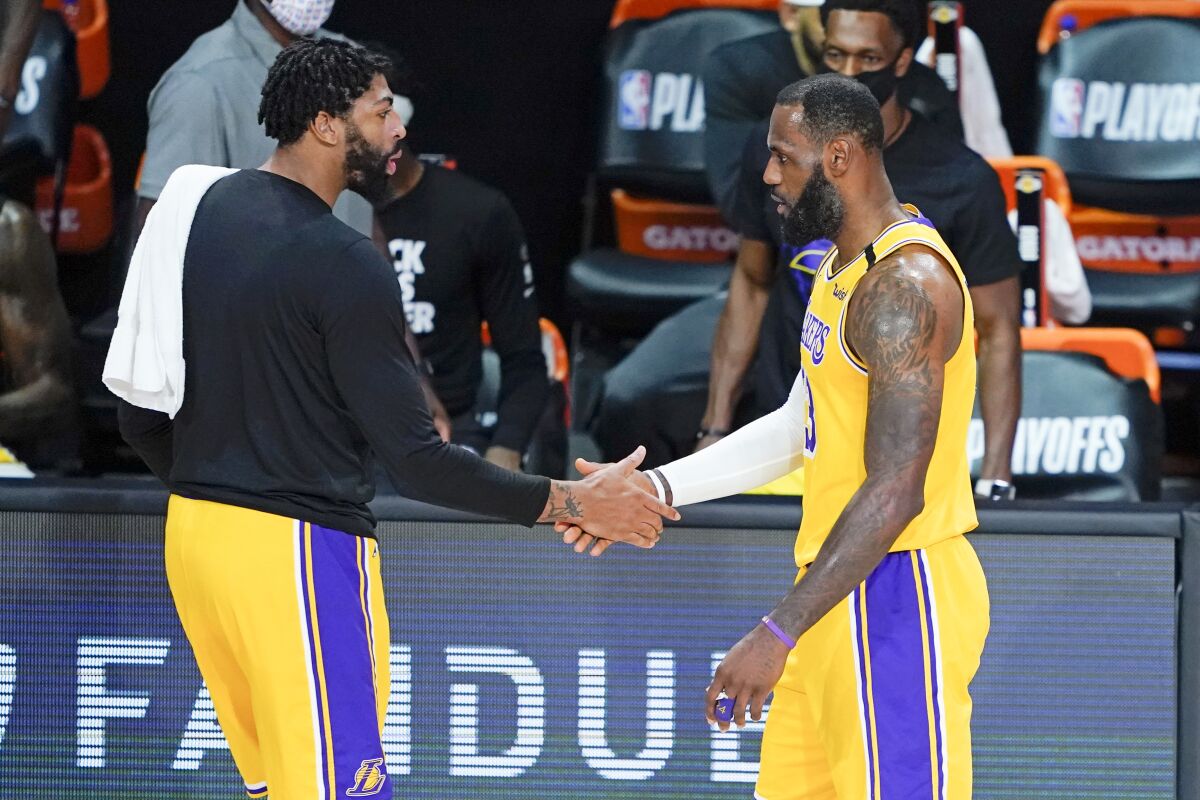 The Lakers' Anthony Davis, left, greets LeBron James as he goes to the bench during the first half Aug. 29, 2020.