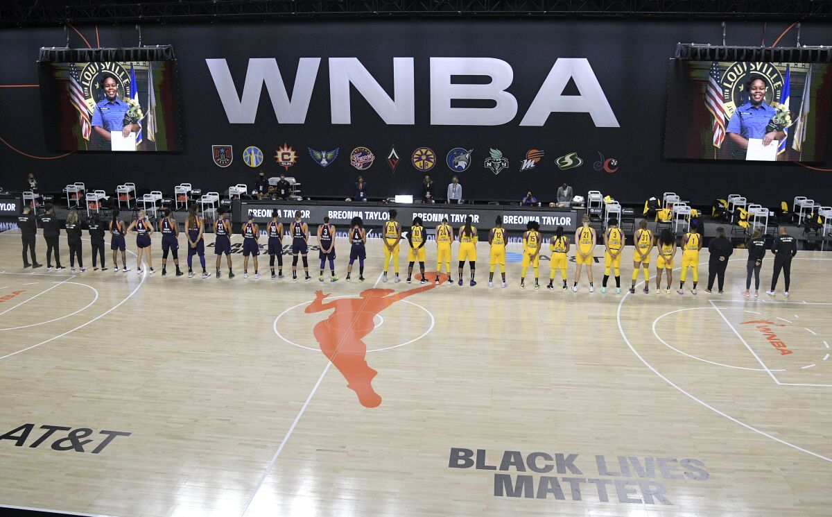 Members of the Phoenix Mercury, left, and Sparks stand for a moment of silence in honor of Breonna Taylor.