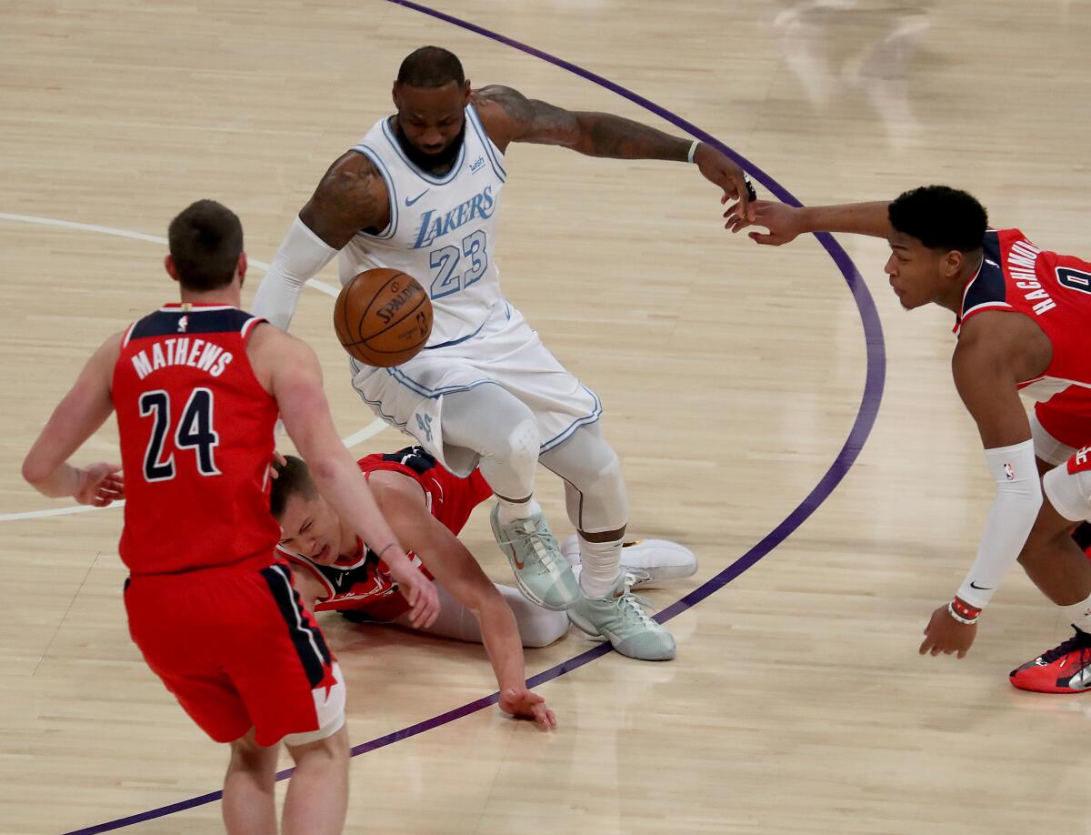 LeBron James fights for control of the ball against a trio of Washington Wizards players.