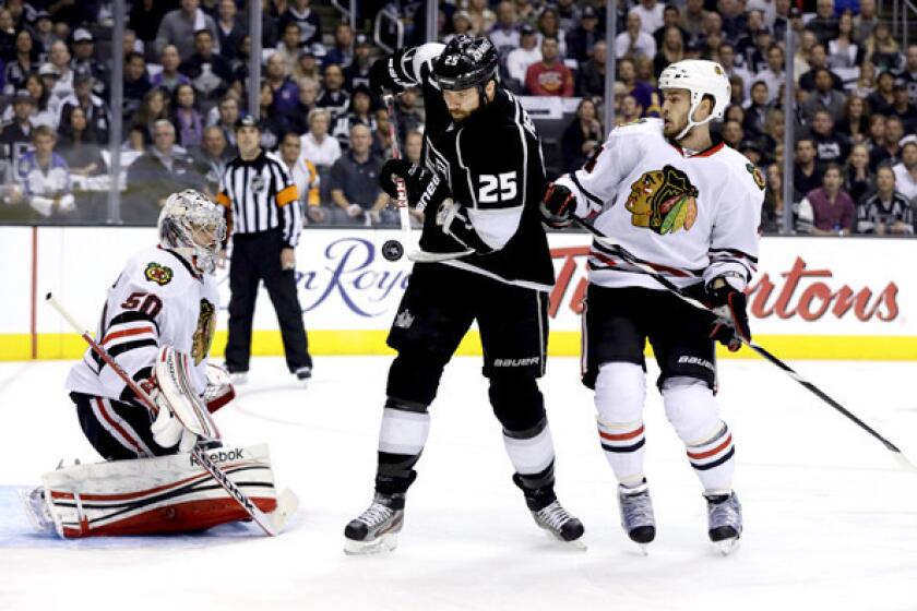Kings winger Dustin Penner tries to redirect the puck between Blackhawks goalie Corey Crawford and defenseman Niklas Hjalmarsson in the first period of Game 4 on Thursday night at Staples Center.