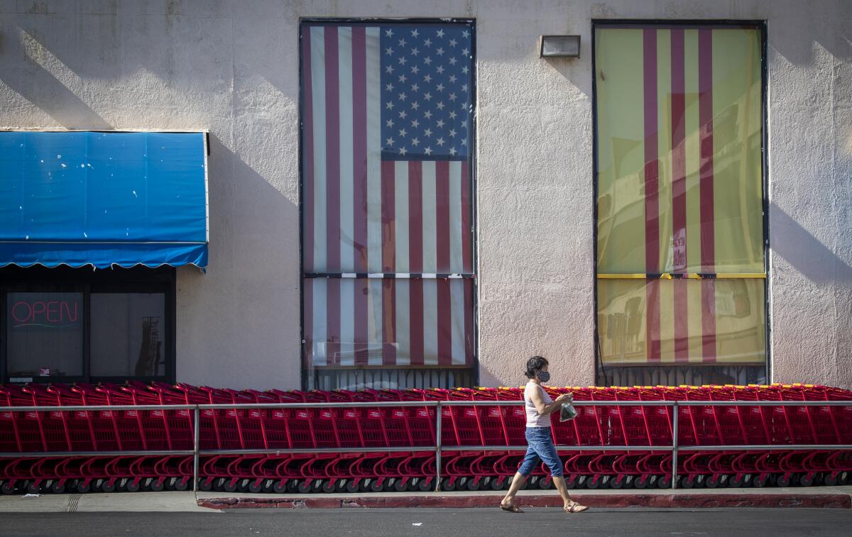 A shopper wearing a protective mask walks by A Dong Supermarket in Little Saigon in Westminster.