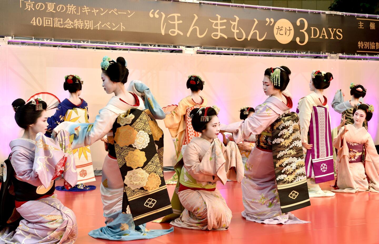 Maikos or apprentice geikos from Japan's ancient capital Kyoto, perform a traditional dance during a special event as part of the Kyoto summer travel campaign in Tokyo on June 21, 2015. The event was held to promote Kyoto tourism.