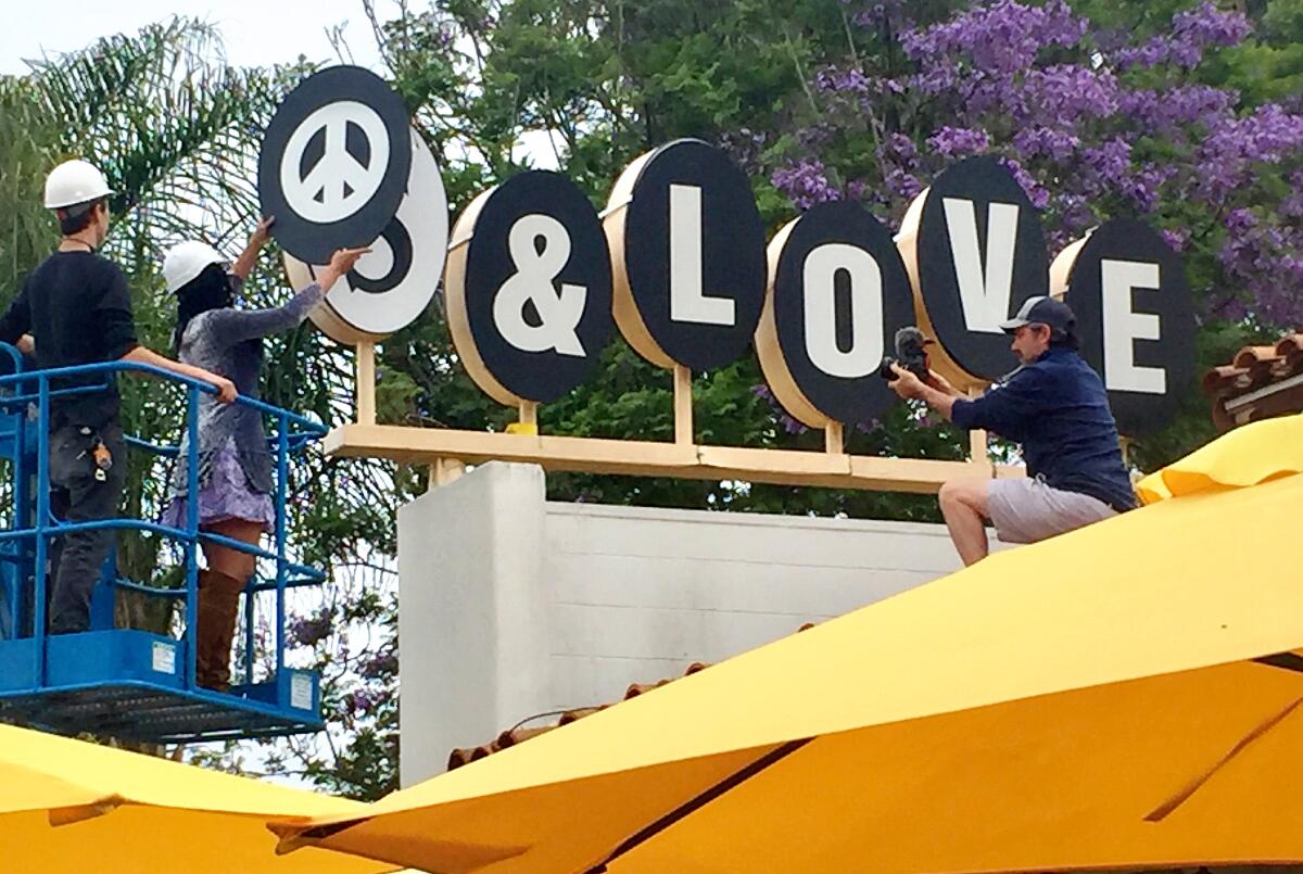 A temporary sign, "peace and love," was affixed over the Sambo's restaurant sign.