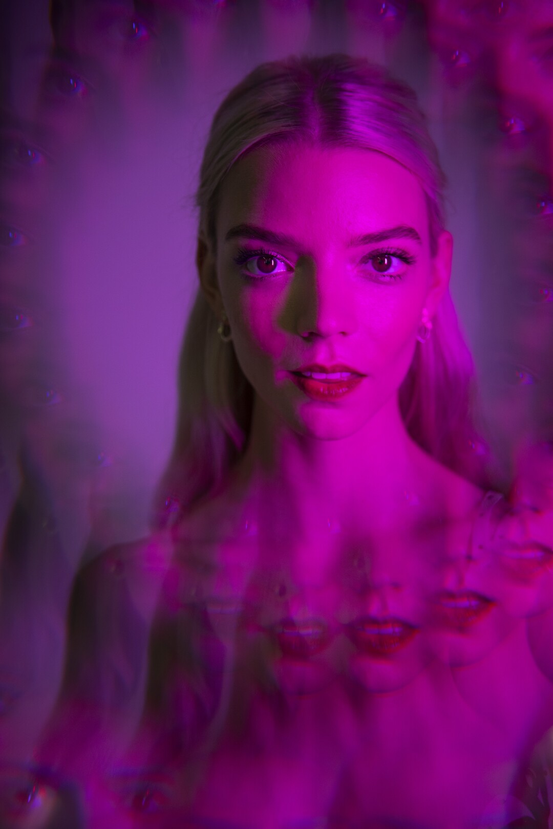 Aug. 6: A woman in a stylized pink lighted image with copies of her mouth on her chest