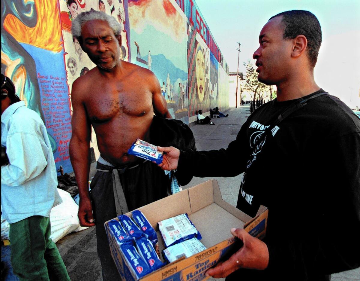 Najee Ali gives food to a homeless man on skid row in 1997.