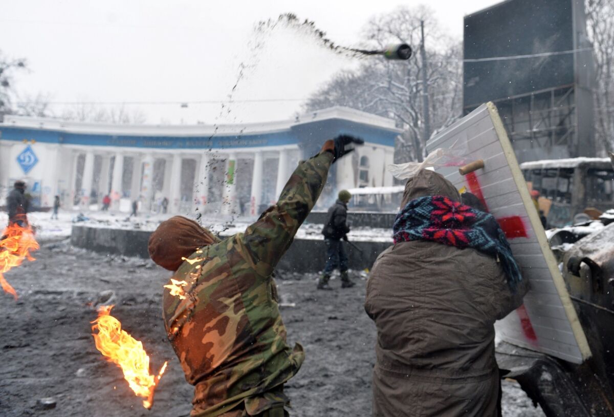 A protester throws a Molotov cocktail at police during clashes in the center of Kiev.