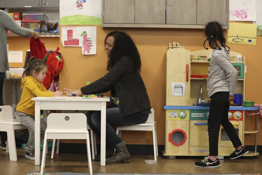 A woman sits at a table with a child