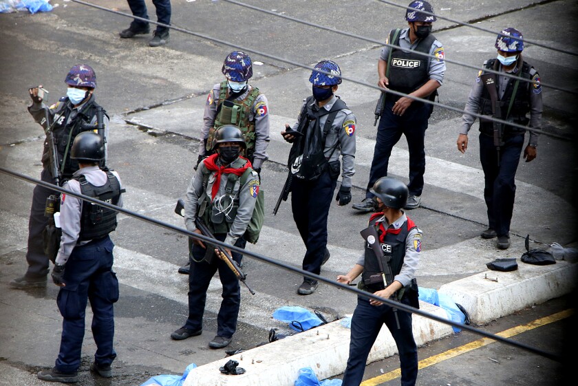 افسران مسلح با لباس فرم و کلاه ایمنی در خیابان ایستاده اند