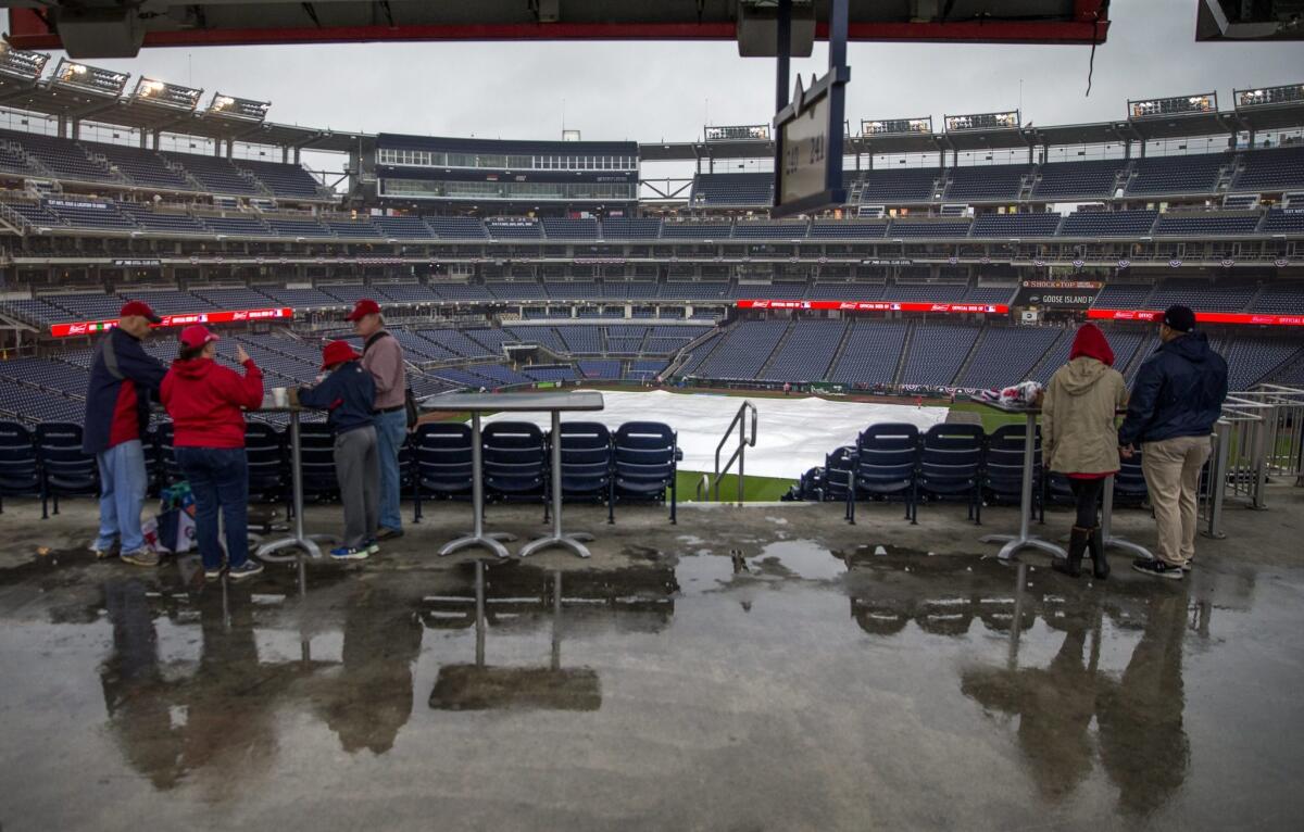 Nationals fans seek shelter from the rain.
