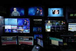 FILE - TV anchor Nesar Nabil is seen on studio monitors wearing a face mask to protest the Taliban's new order that female presenters cover their faces, as he reads the news on TOLOnews, in Kabul, Afghanistan, Sunday, May 22, 2022. (AP Photo/Ebrahim Noroozi, File)