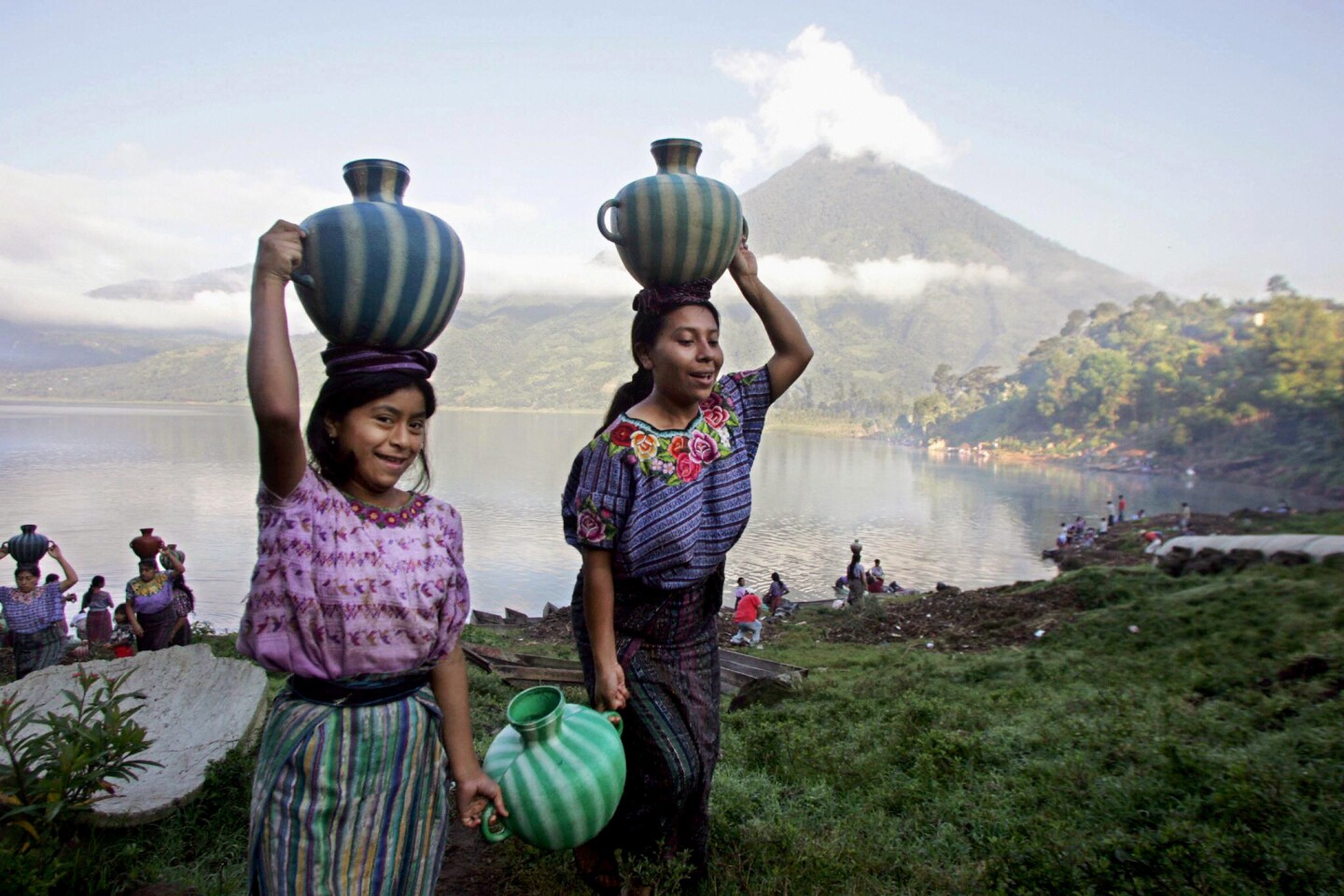 Indigenous women carry receptacles with water from the Atitlan lake in 2005.