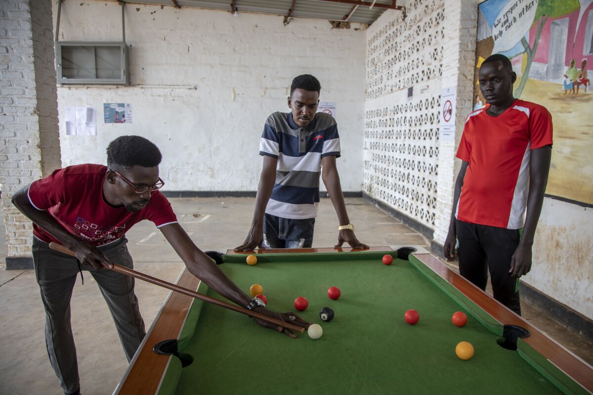 Peter Nyuoni, right, from Sudan, who was evacuated from Libya to Rwanda, plays pool with others at the Gashora transit center for refugees and asylum-seekers, in the Bugesera district of Rwanda Friday, June 10, 2022. As Britain plans to send its first group of asylum-seekers to Rwanda amid outcries and legal challenges, some who came there from Libya under earlier arrangements with the United Nations say the new arrivals can expect a difficult time ahead. (AP Photo)
