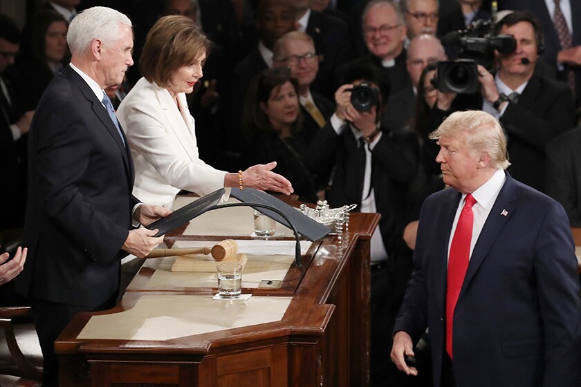 House Speaker Nancy Pelosi attempts to shake hands with President Trump