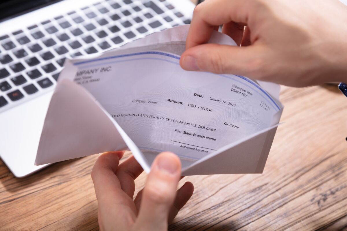 Person removing paycheck from envelope