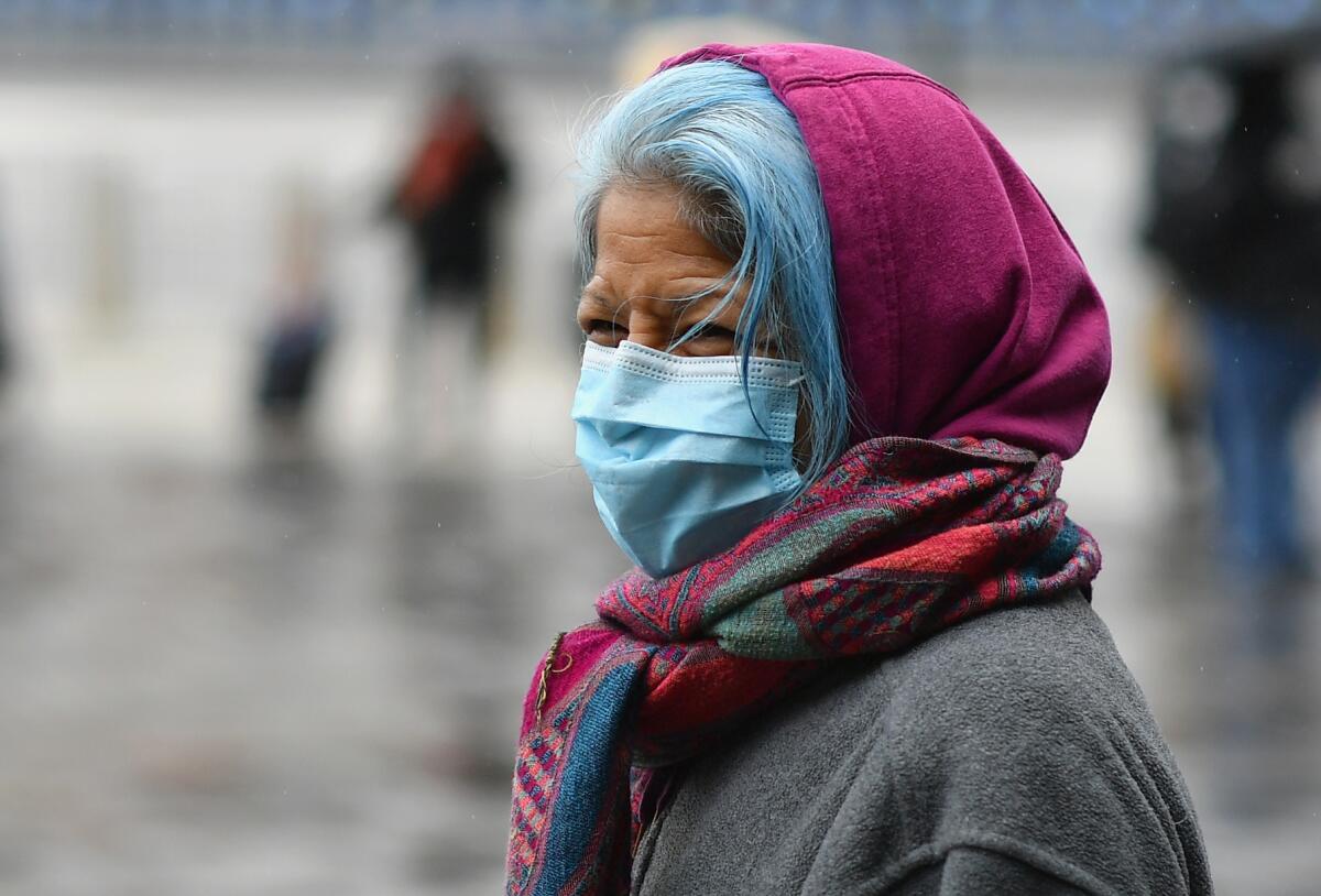 A woman waits in line in Brooklyn for a mobile food pantry.