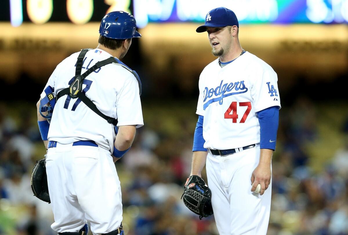 Dodgers pitcher Paul Maholm, right, talks with catcher A.J. Ellis in the fourth inning. Maholm gave up 10 runs, five earned, in the Dodgers' 13-3 loss to the Marlins.