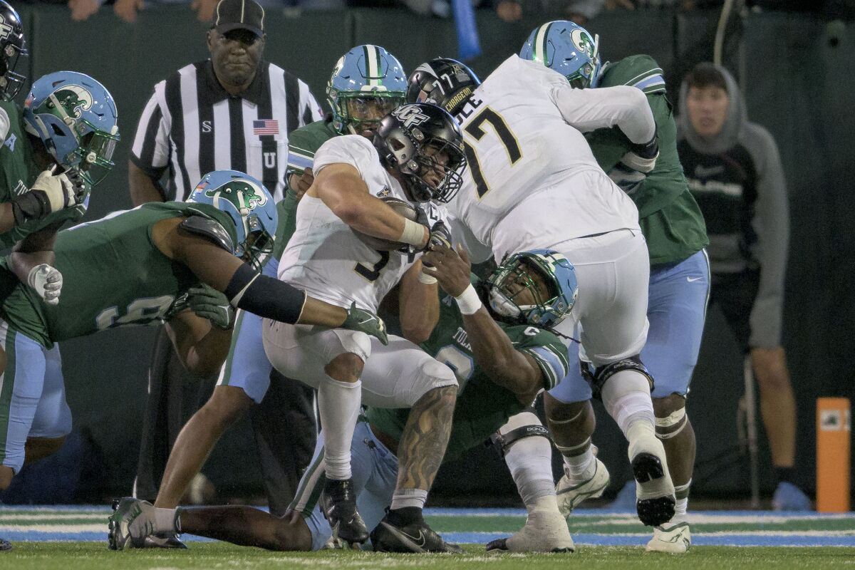 UCF running back Isaiah Bowser runs against Tulane linebacker Dorian Williams during the second half of an NCAA college football game in New Orleans, Saturday, Nov. 12, 2022. (AP Photo/Matthew Hinton)