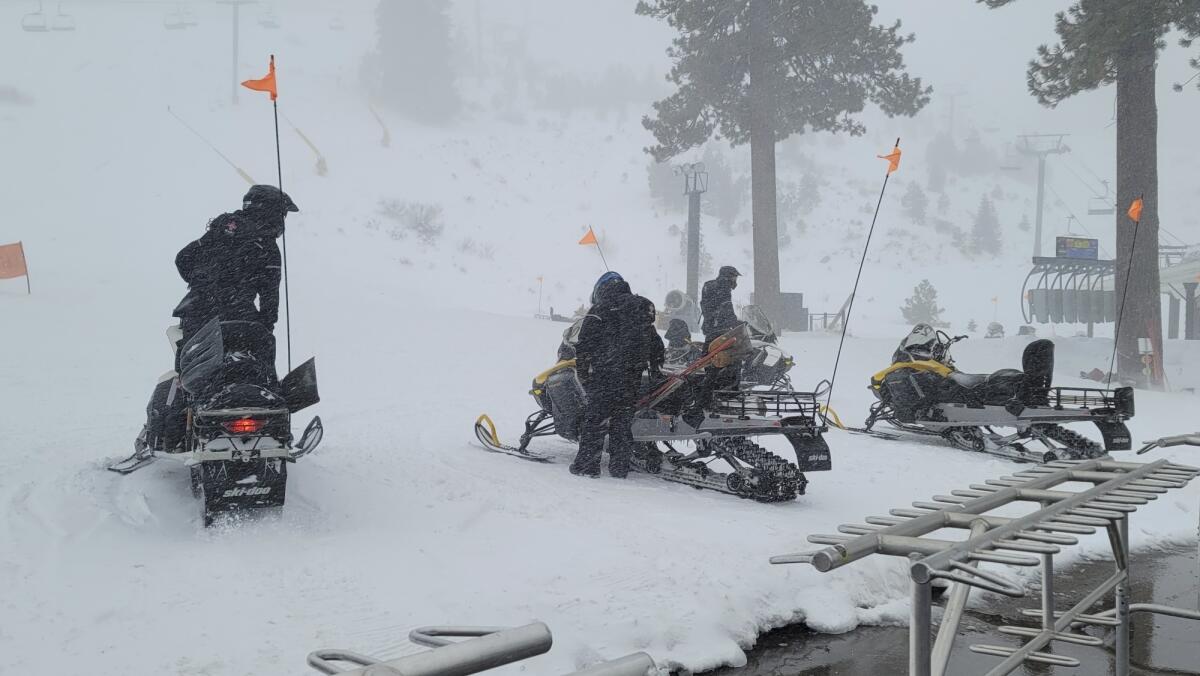 People on snowmobiles in a snowstorm. 
