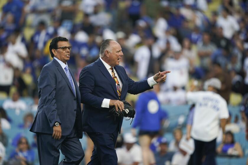 Fernando Valenzuela walks with Mike Scioscia after throwing out the first pitch before a game last season. 
