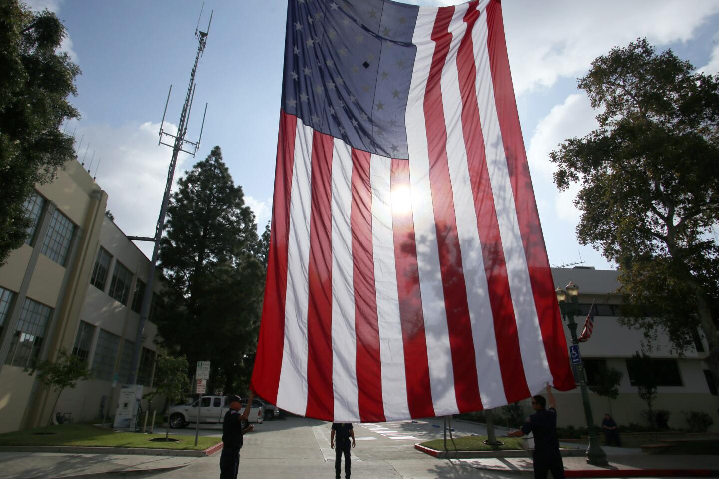 The flag of the United States of America is lowered by members of the Glendale Fire Department during a memorial ceremony on the 18th anniversary of the September 11 attacks, the ceremony took place in front of the Glendale Police Department on Isabel Street in Glendale, Ca., Wednesday, September 11, 2019. (photo by James Carbone)