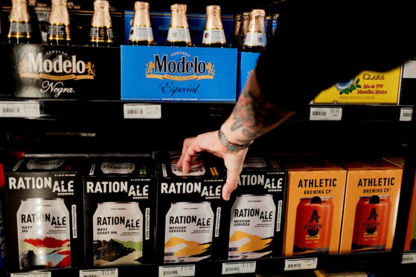A man reaches for a 12-pack of RationAle beer at a liquor store.
