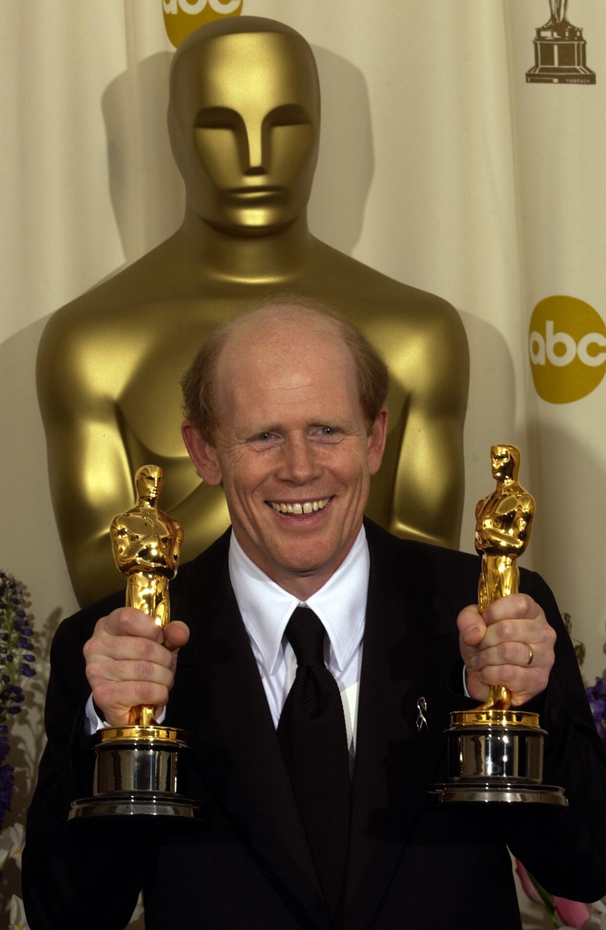 Ron Howard holds two Oscar statuettes at the 2002 ceremony.