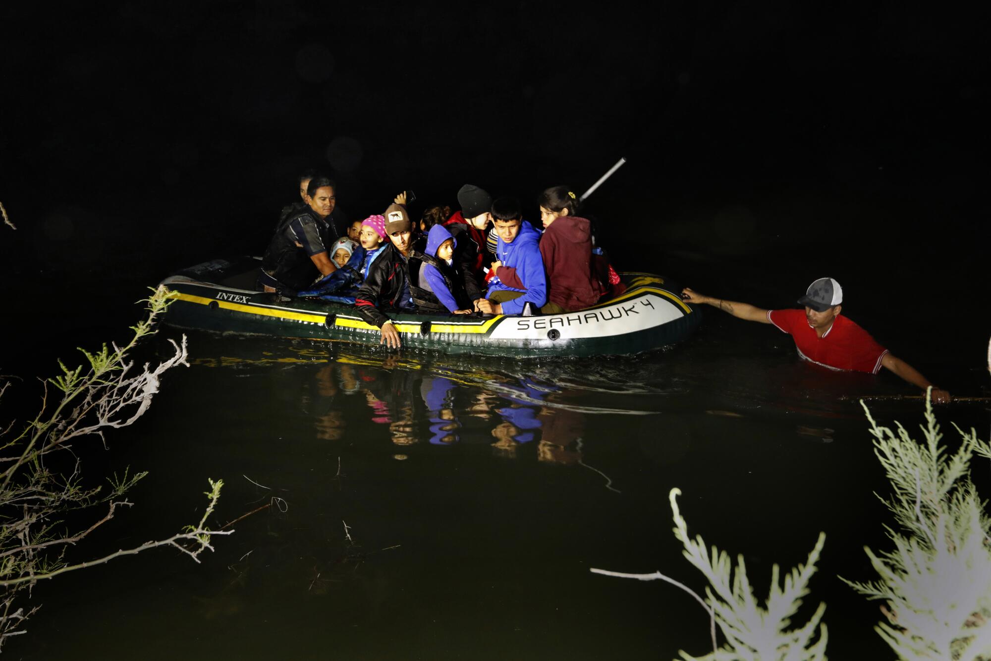Asylum seekers cross the Rio Grande River in an inflatable raft 