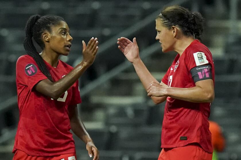 Canada's Christine Sinclair, right, is congratulated by teammate Ashley Lawrence.