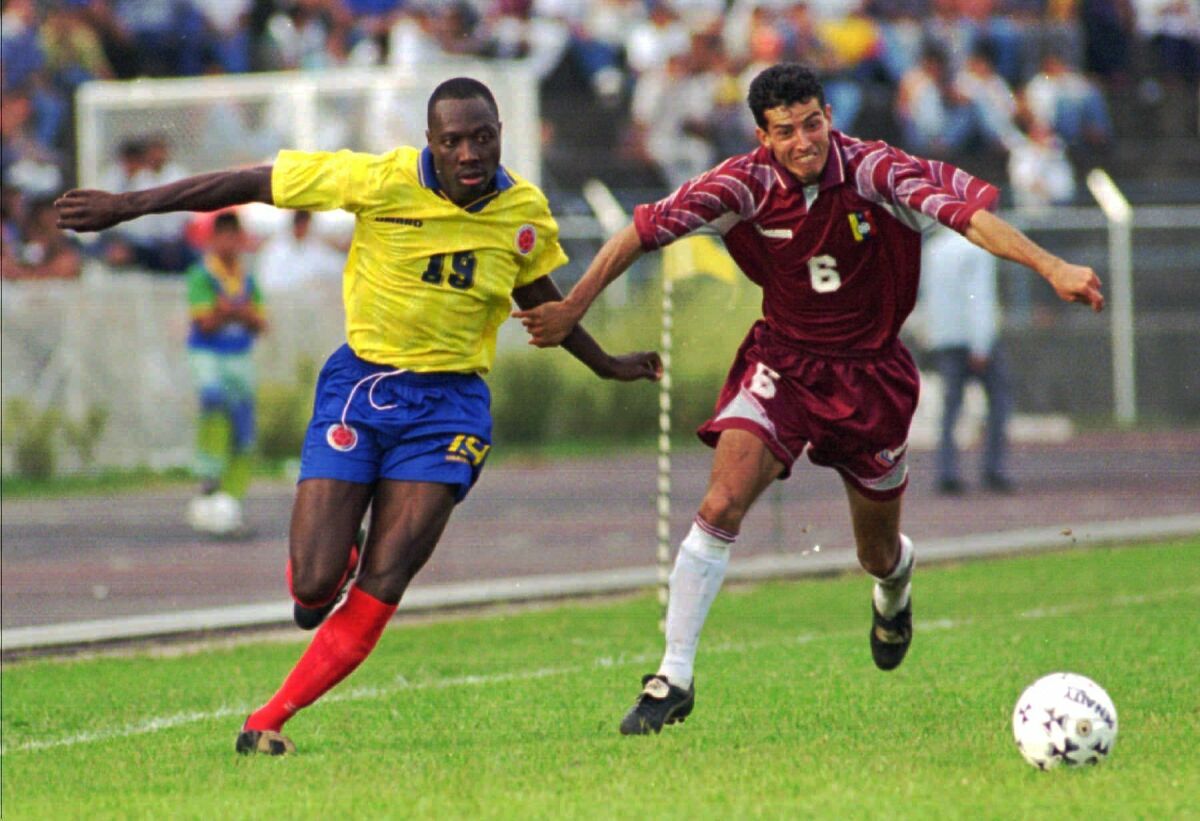 FILE - Colombian player Freddy Rincon, left, fights for the ball with Elvis Martinez of Venezuela during a qualifying France '98 game in San Cristobal, Venezuela, on Dec. 15, 1996. Former Colombian national soccer team captain Freddy Rincón has died. He was 55. Rincón played in three World Cups for Colombia and also played for Real Madrid, Parma and Napoli. He died after being injured in a car crash on Monday when his vehicle collided with a bus in Cali, Colombia. (AP Photo/Jose Caruci, File)