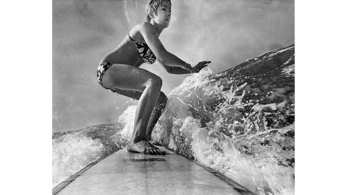 Feb. 24, 1970: Linda Benson, five-time world surfing champion, rides wave in front of her Hermosa Beach home.