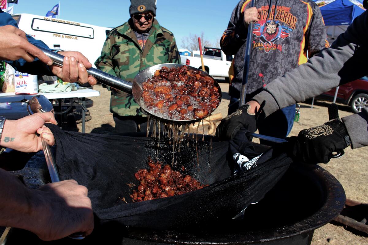 The Matanzeros strain out lard from chicharrones.