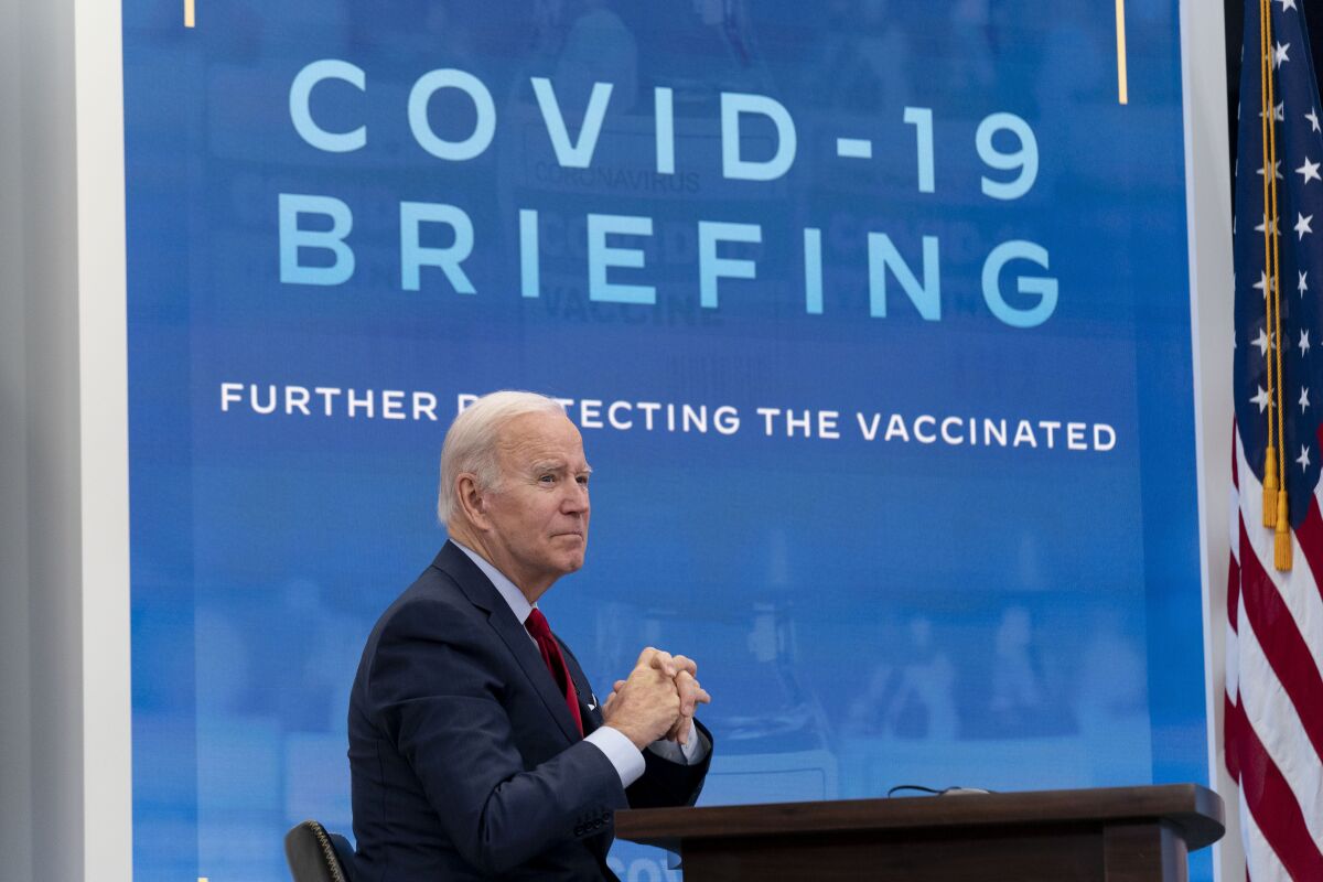 President Biden sits with hands clasped at a meeting of the White House COVID-19 response team