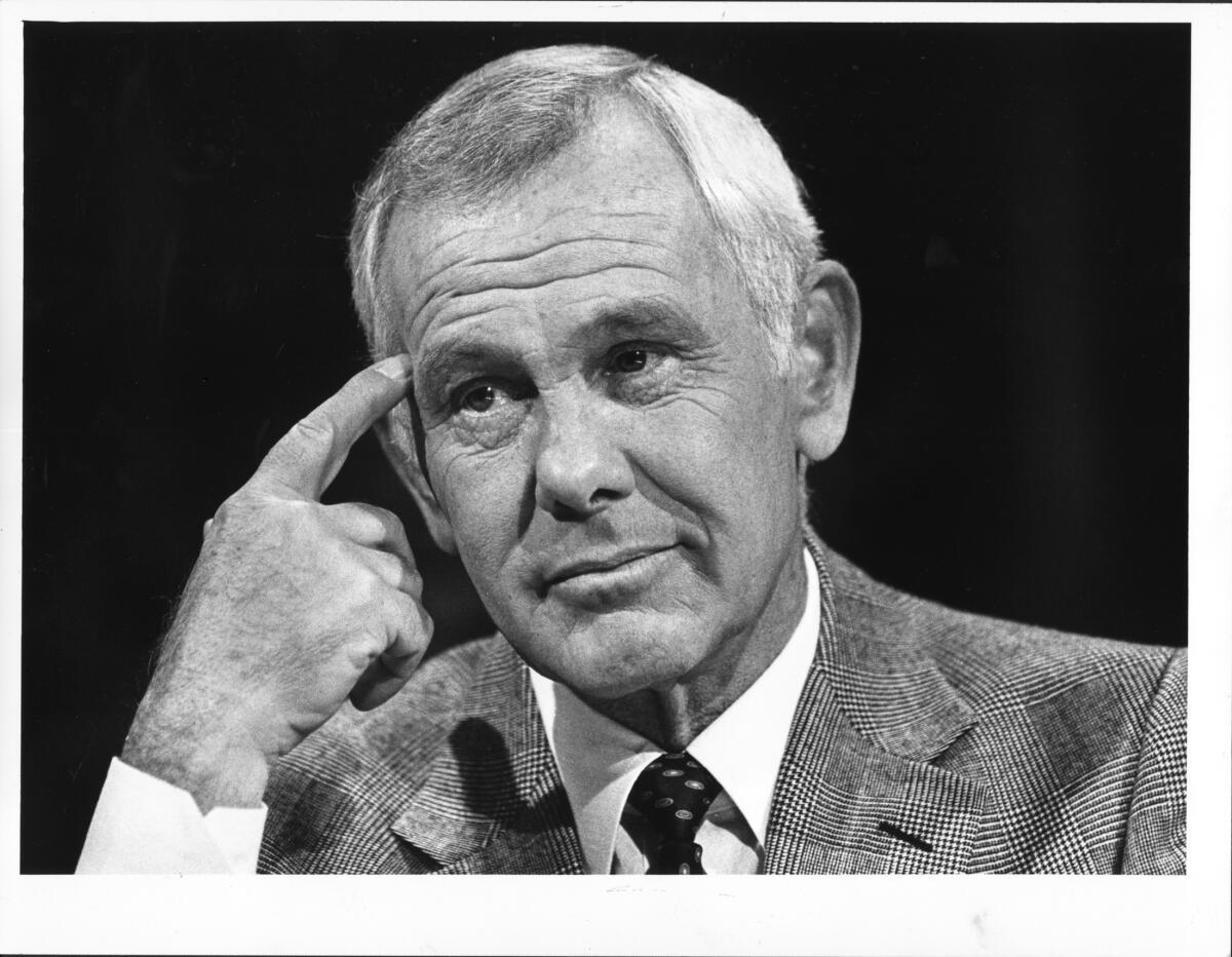 Closeup of a man with gray hair and wearing a suit and tie.