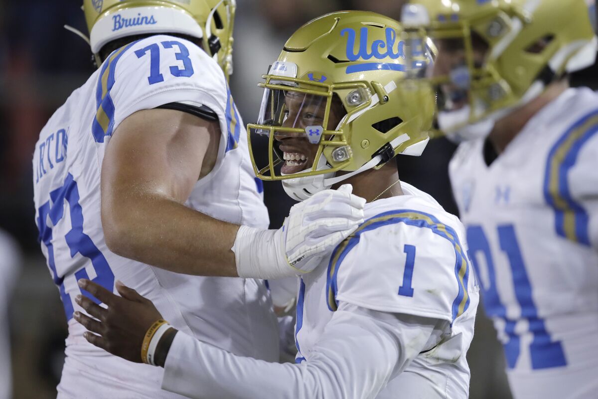UCLA quarterback Dorian Thompson-Robinson, right, celebrates with teammate Jake Burton after scoring a touchdown against Stanford in the first half Thursday.