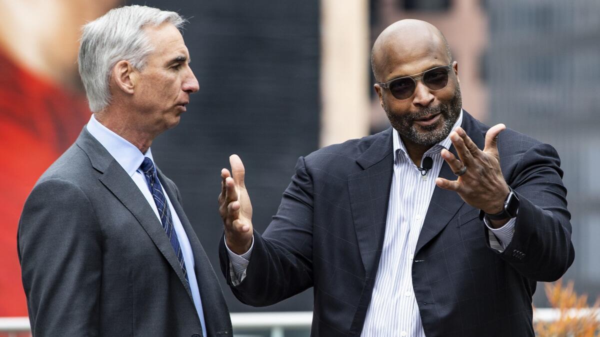 XFL Commissioner and CEO Oliver Luck, left, announces that Winston Moss, right, former associate head coach of the Green Bay Packers, will be the head coach of the XFL’s Los Angeles team during a news conference on The Terrace at L.A. LIVE on Tuesday.