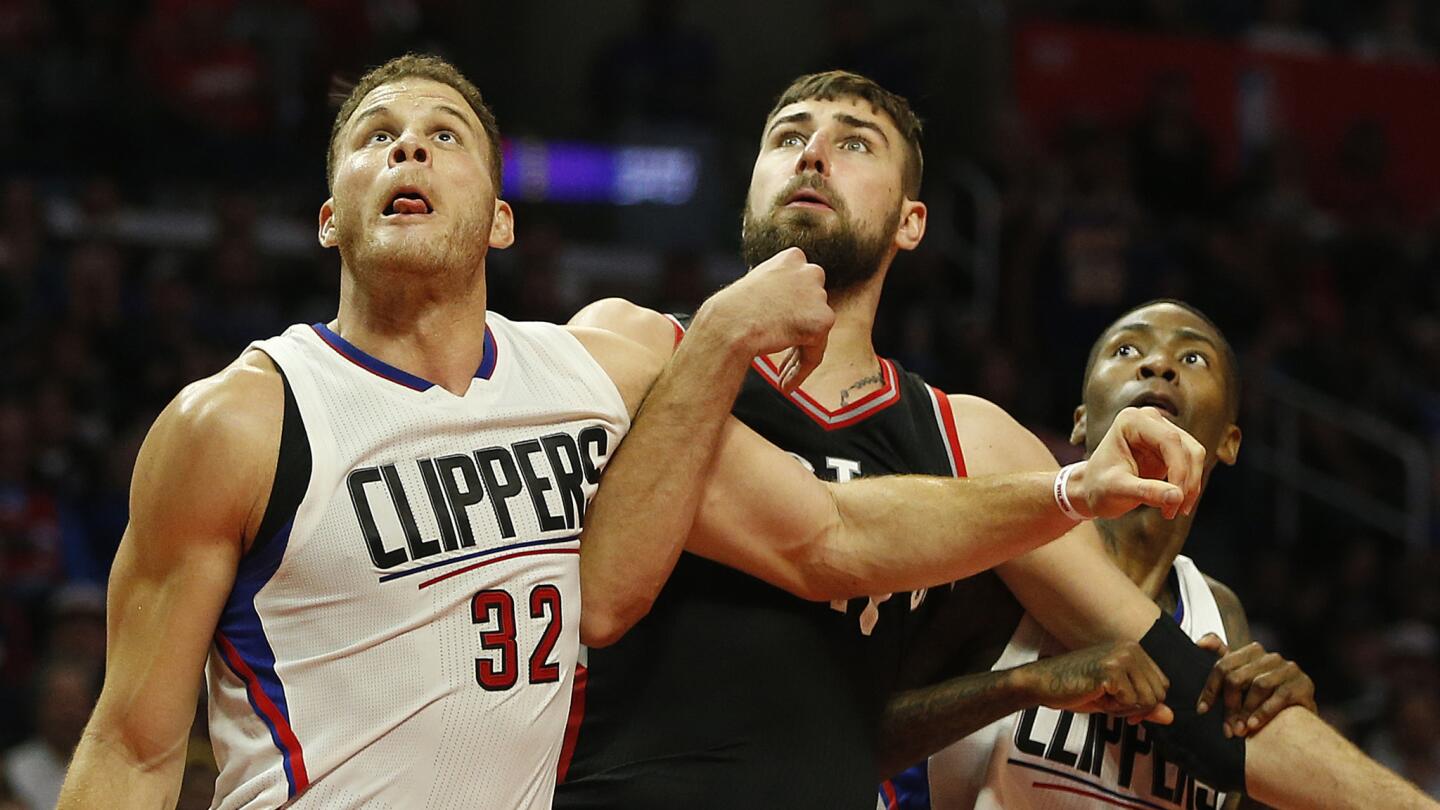 Clippers forward Blake Griffin and guard Jamal Crawford squeeze out Raptors center Jonas Valanciunas under the board in the second half.