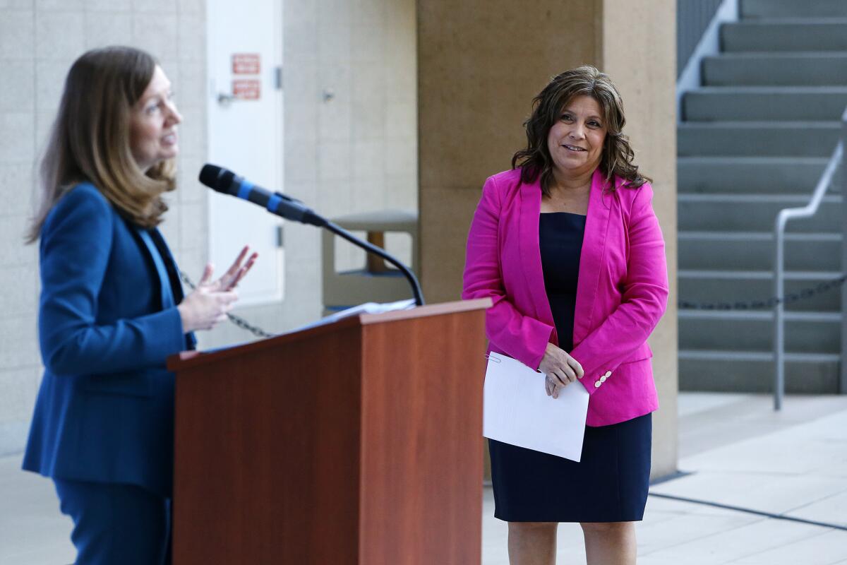 Marciela Rios-Faust, right, chief executive of nonprofit Human Options, at a press conference.