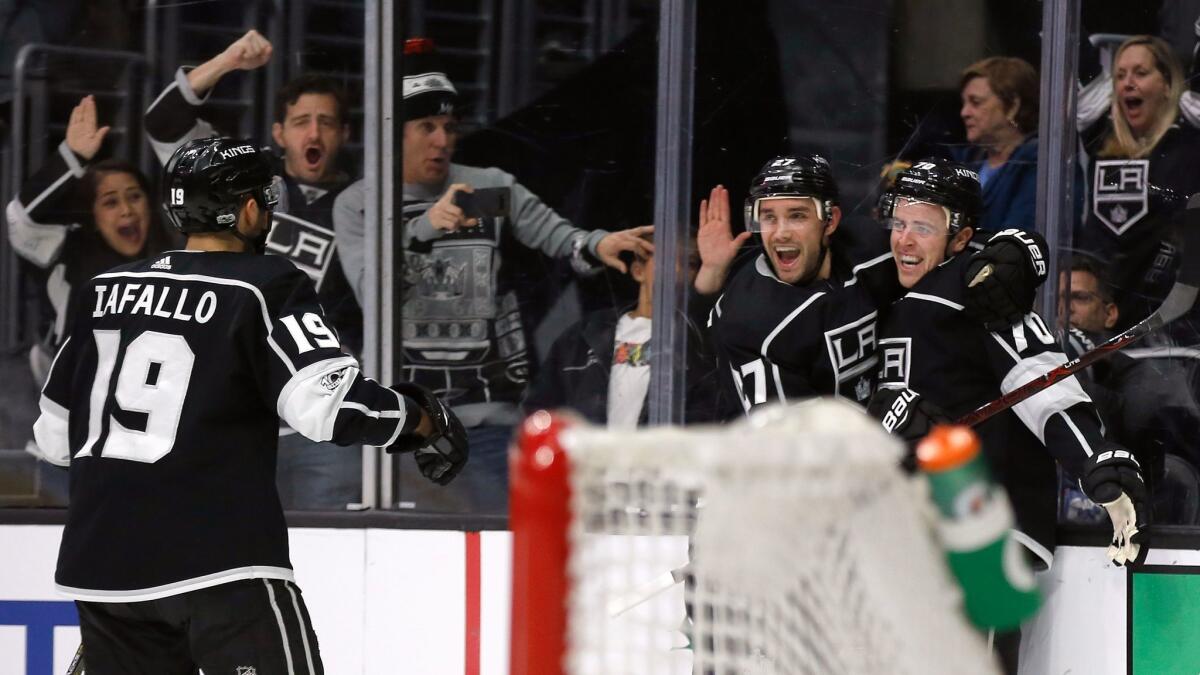 Los Angeles Kings left wing Tanner Pearson, right, celebrates his overtime goal with defenseman Alec Martinez, second from right, and center Alex Iafallo, against the Carolina Hurricanes.