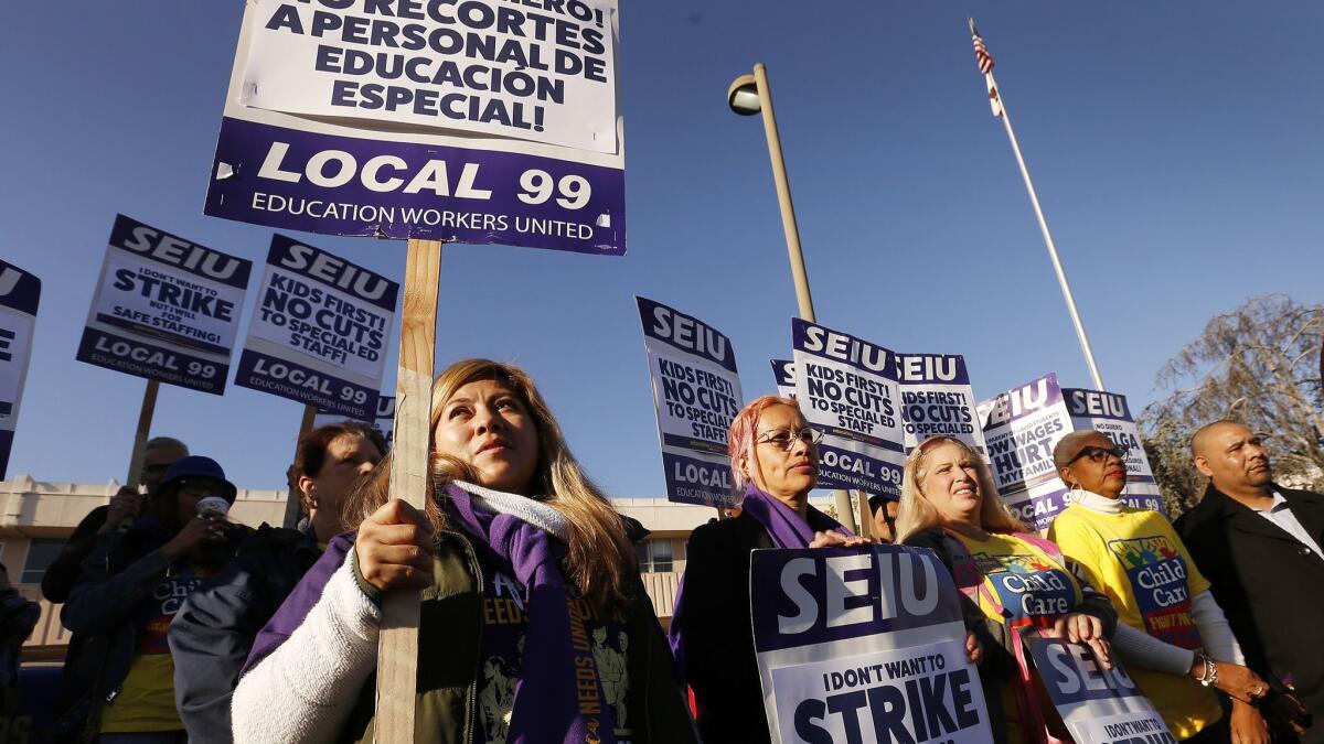 Los Angeles campus aide Nancy Ramirez-Chavez, left, joins other school workers in a February demonstration at Marlton School for a better contract. Union leaders reached a tentative deal Tuesday.