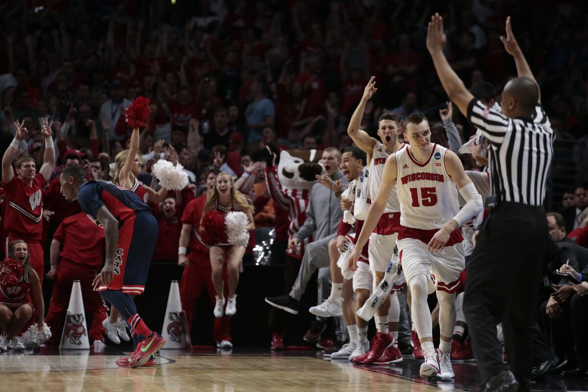 Teammates and fans celebrate after Wisconsin forward Sam Dekker sinks a three-point shot late in the game to help seal a victory over Arizona in the West Regional final on Saturday at Staples Center.