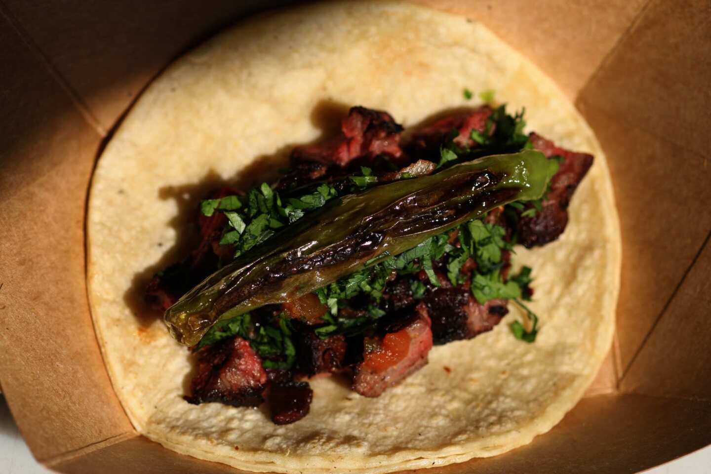 The hanger steak taco includes a blistered shisito pepper.