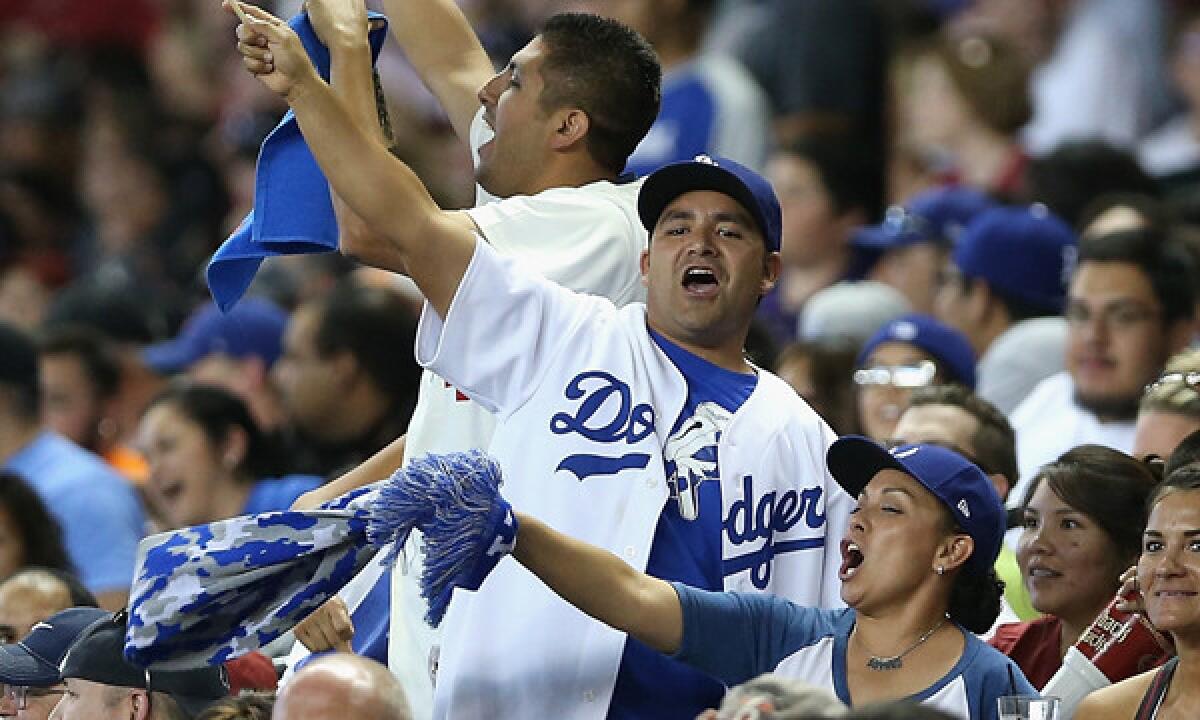 Dodgers fans cheer on the team during a game against the Arizona Diamondbacks at Chase Field in Phoenix on Sunday.