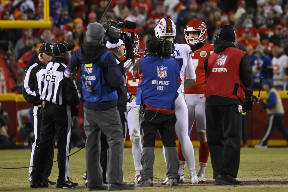 The Kansas City Chiefs and Buffalo Bills meet at midfield for the overtime coin toss.